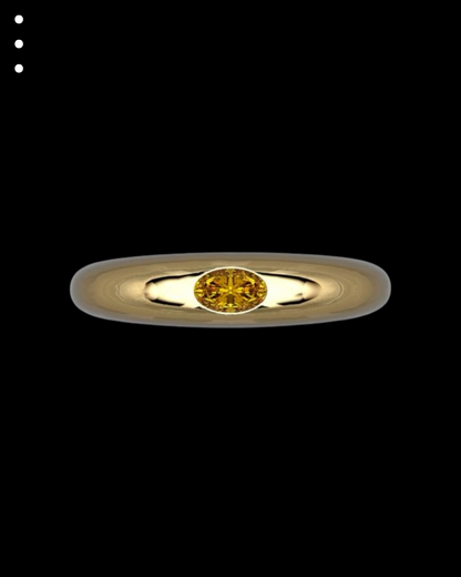Gold ring with a yellow gemstone on a black background